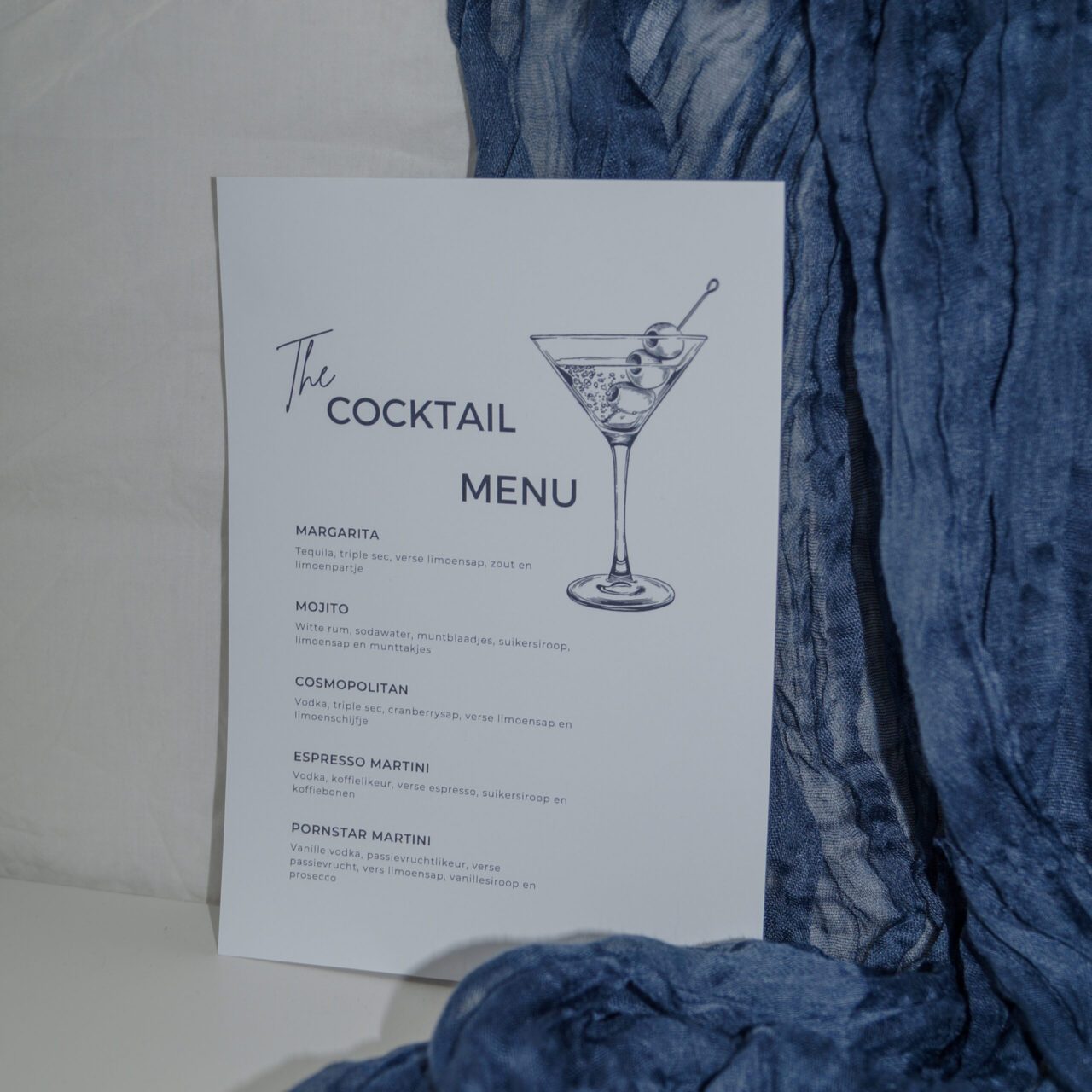 Cocktailmenu op tafel met blauwe tafelloper