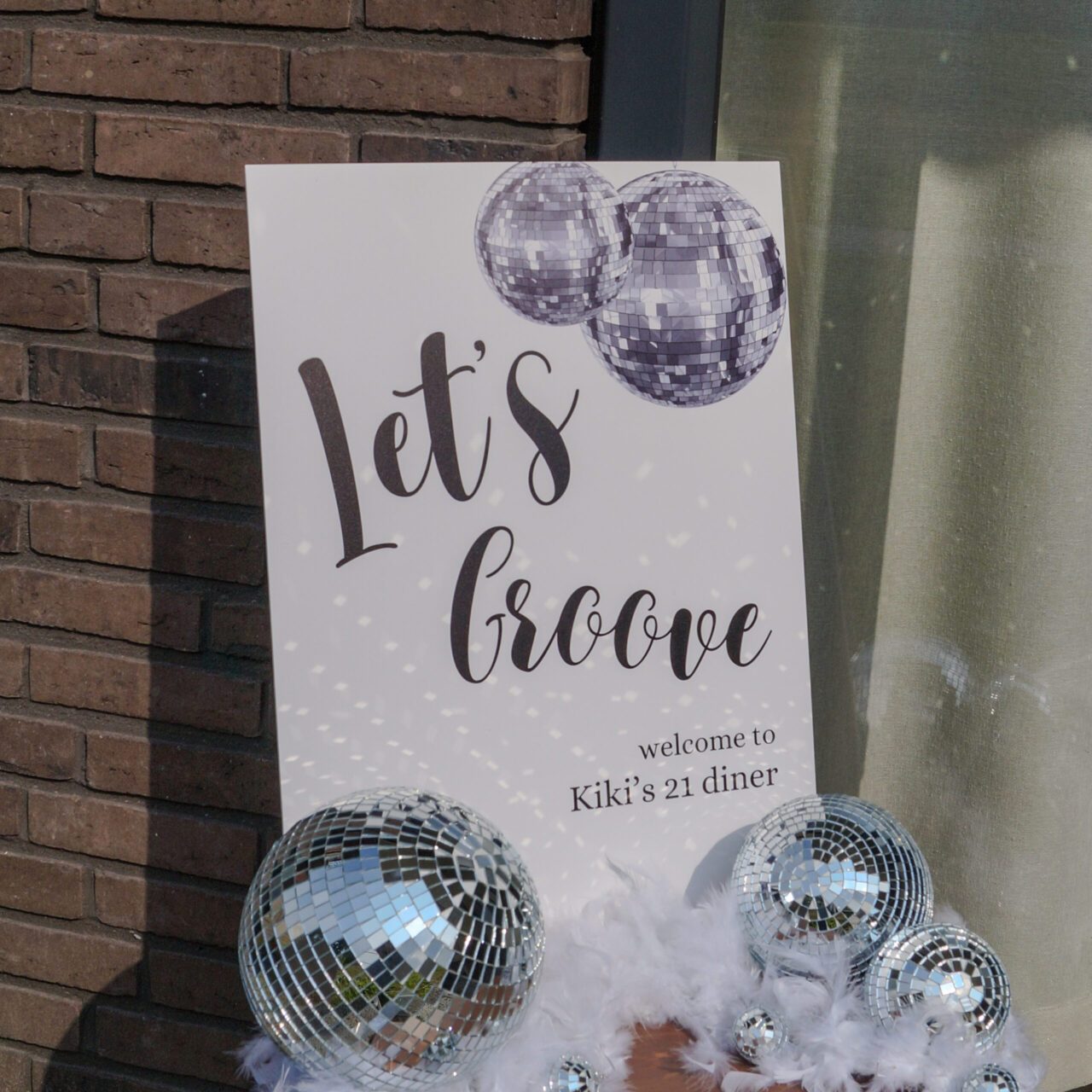 Welkomstbord 'Let's groove' met discoballen voor een 21-diner